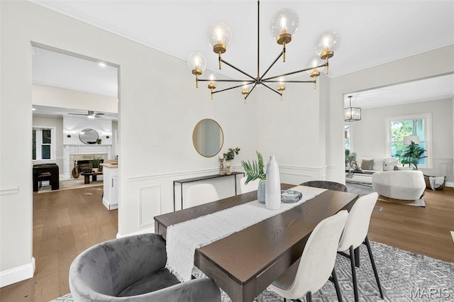 317 Greeley Ave, Webster Groves, MO 63119 - dining area featuring a chandelier, ornamental molding, wood finished floors, and a fireplace