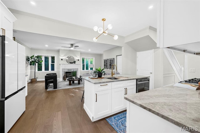 317 Greeley Ave, Webster Groves, MO 63119 - kitchen featuring freestanding refrigerator, dark wood-type flooring, a fireplace, white cabinetry, and crown molding