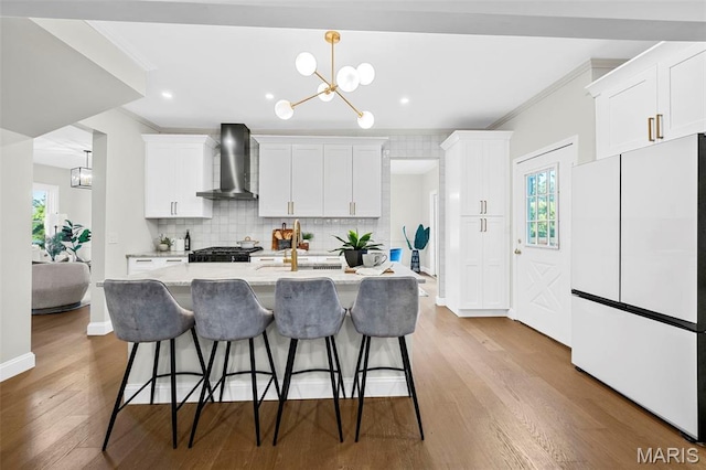 317 Greeley Ave, Webster Groves, MO 63119 - kitchen with freestanding refrigerator, wall chimney range hood, ornamental molding, a chandelier, and a kitchen breakfast bar