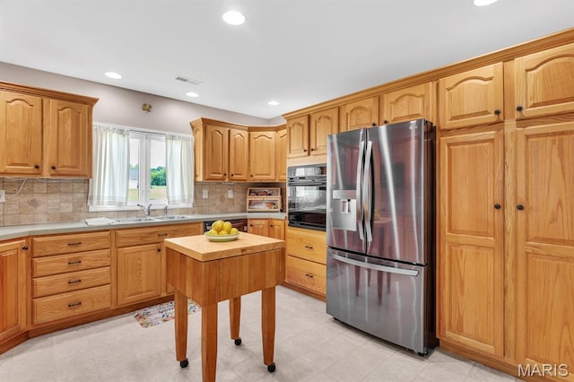 61 Serenity Ln, Troy, MO 63379 - kitchen with stainless steel fridge, black oven, a sink, tasteful backsplash, and recessed lighting
