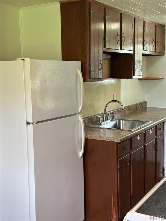 1707 Cross St, Ofallon, IL 62269 - kitchen featuring freestanding refrigerator, a sink, decorative backsplash, open shelves, and dark countertops
