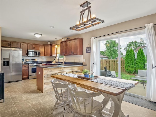 628 Hailie St, Saint Libory, IL 62282 - kitchen with appliances with stainless steel finishes, a sink, dark countertops, a peninsula, and light tile patterned floors