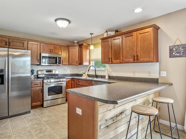 628 Hailie St, Saint Libory, IL 62282 - kitchen featuring stainless steel appliances, dark countertops, a sink, brown cabinetry, and a peninsula