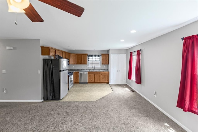 209 S Pence St, East Alton, IL 62024 - kitchen featuring appliances with stainless steel finishes, light carpet, brown cabinets, baseboards, and ceiling fan
