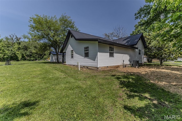 711 Noe Dr, Richland, MO 65556 - view of side of property with a lawn, metal roof, and central AC