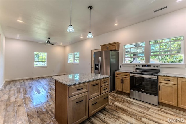 711 Noe Dr, Richland, MO 65556 - kitchen featuring appliances with stainless steel finishes, light wood-style floors, a kitchen island, a ceiling fan, and hanging light fixtures