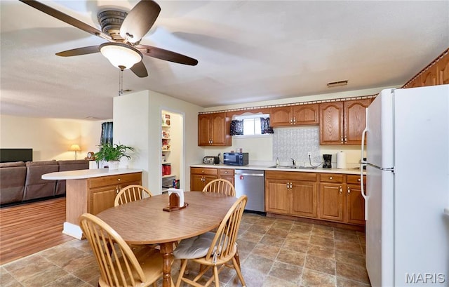 24925 Pike 244, Clarksville, MO 63336 - kitchen with dishwasher, freestanding refrigerator, a sink, stone finish floors, and light countertops
