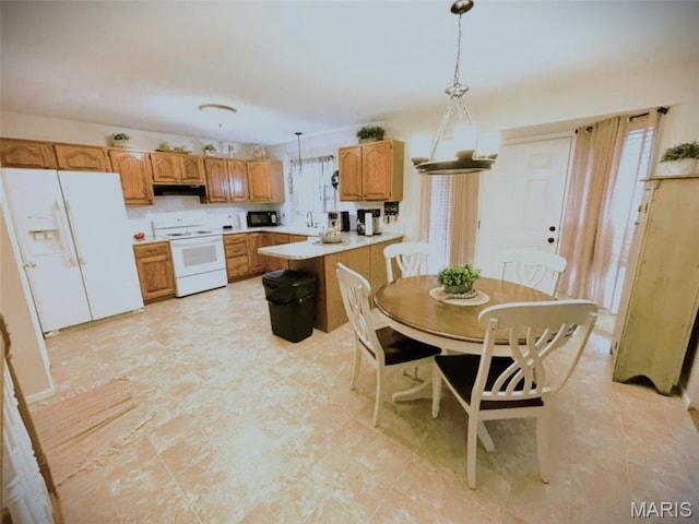 16 S Lang Dr, Ofallon, MO 63366 - kitchen with white appliances, light countertops, decorative light fixtures, a peninsula, and brown cabinets