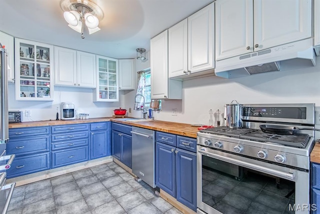 1956 Parkton W Dr, Barnhart, MO 63012 - kitchen with appliances with stainless steel finishes, butcher block counters, blue cabinets, under cabinet range hood, and white cabinets