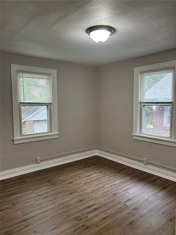 8324 Strathmore Pl, Jennings, MO 63136 - unfurnished room featuring dark wood finished floors and baseboards