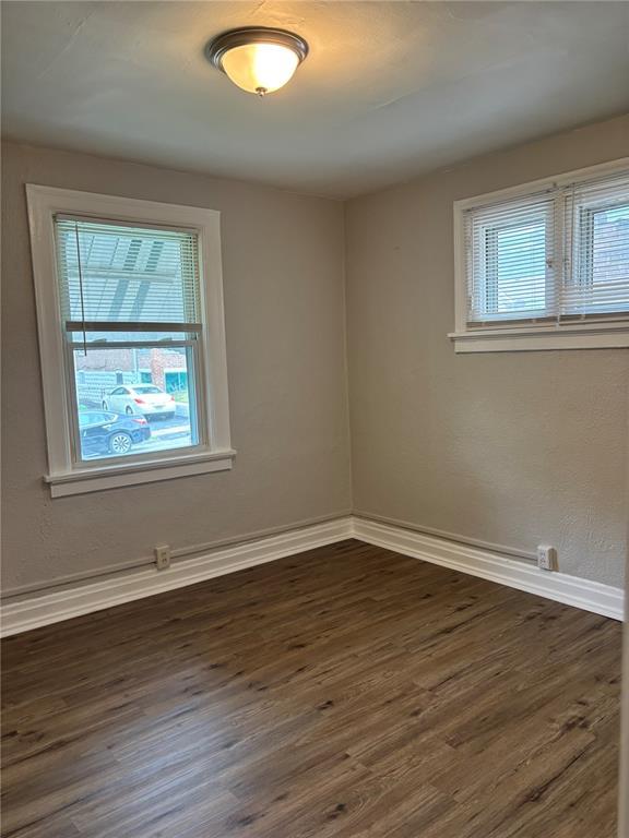 8324 Strathmore Pl, Jennings, MO 63136 - spare room featuring dark wood-type flooring and baseboards