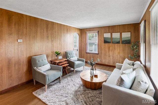 100 Bonds Ave, East Alton, IL 62024 - sitting room featuring wood finished floors, wood walls, a textured ceiling, baseboards, and arched walkways