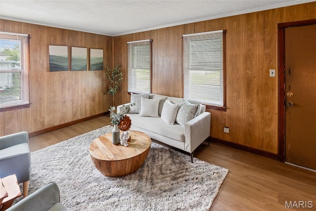 100 Bonds Ave, East Alton, IL 62024 - living room with healthy amount of natural light, wood finished floors, wooden walls, baseboards, and a textured ceiling