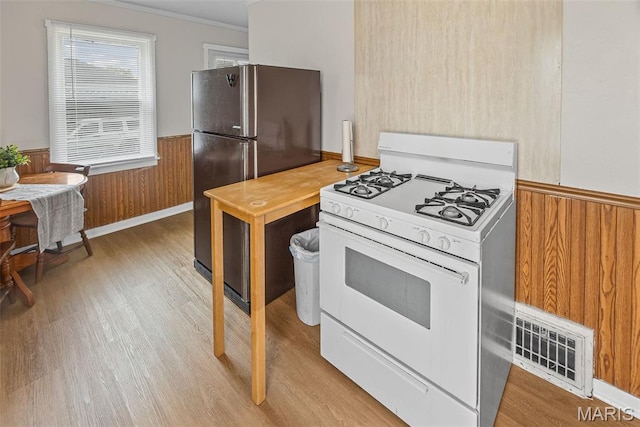 100 Bonds Ave, East Alton, IL 62024 - kitchen with white gas range, freestanding refrigerator, wainscoting, light wood-type flooring, and ornamental molding