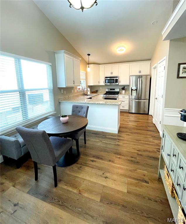 259 Jacob Ln, Ballwin, MO 63021 - kitchen with appliances with stainless steel finishes, lofted ceiling, a peninsula, dark wood-type flooring, and white cabinets