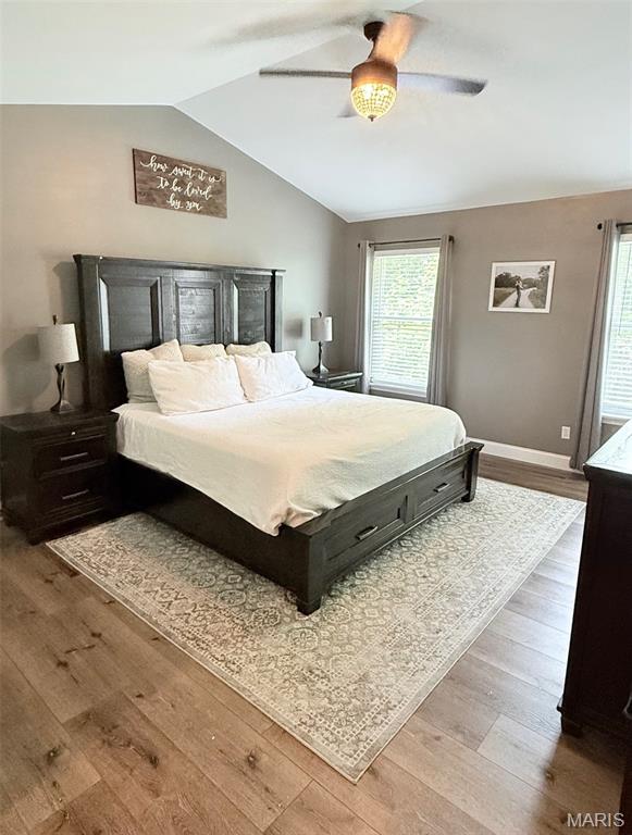 259 Jacob Ln, Ballwin, MO 63021 - bedroom with wood finished floors, vaulted ceiling, multiple windows, baseboards, and ceiling fan