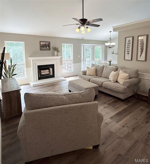 259 Jacob Ln, Ballwin, MO 63021 - living room with dark wood-style floors, a wainscoted wall, a ceiling fan, a decorative wall, and a fireplace with raised hearth