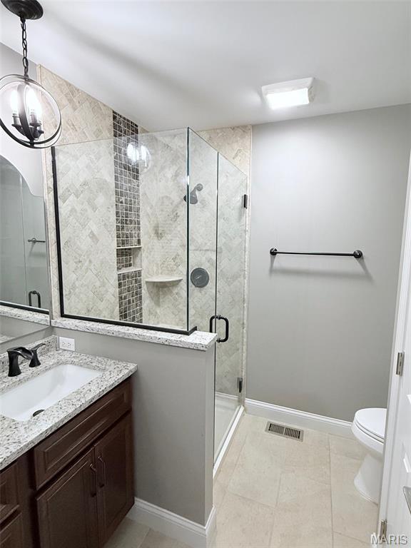 259 Jacob Ln, Ballwin, MO 63021 - bathroom featuring vanity, a shower stall, toilet, baseboards, and a chandelier