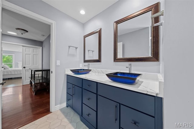16434 Wilson Farm Dr, Chesterfield, MO 63005 - ensuite bathroom with double vanity, baseboards, and wood finished floors