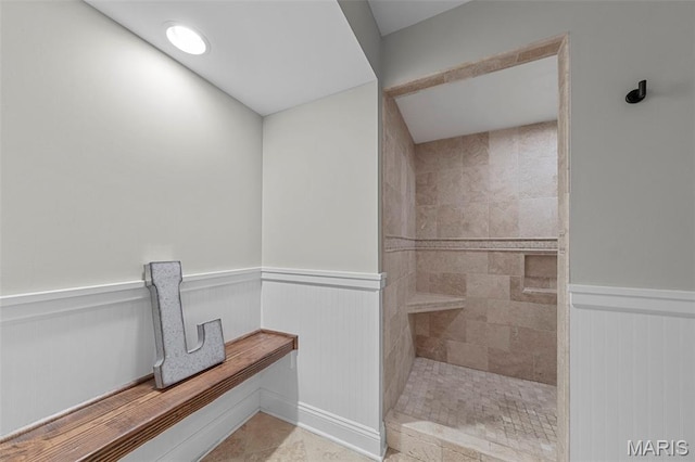 16434 Wilson Farm Dr, Chesterfield, MO 63005 - bathroom featuring a wainscoted wall and a tile shower
