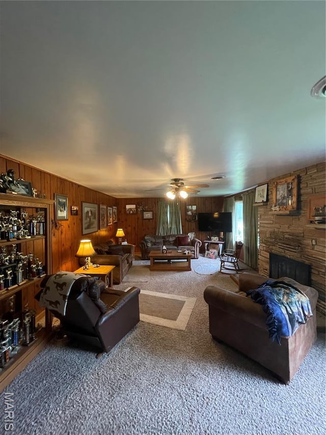 623 County Road 6590, Salem, MO 65560 - carpeted living room with wooden walls, a stone fireplace, and a ceiling fan