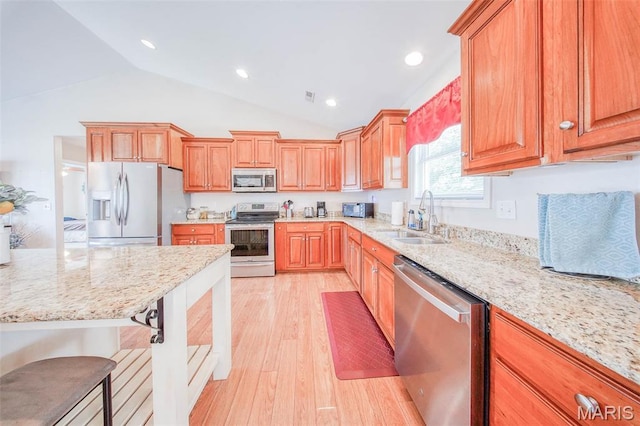 11195 Lexington Ln, Rolla, MO 65401 - kitchen with stainless steel appliances, a sink, vaulted ceiling, light wood-type flooring, and light stone countertops