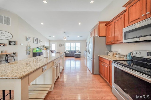 11195 Lexington Ln, Rolla, MO 65401 - kitchen with appliances with stainless steel finishes, light stone countertops, light wood finished floors, open floor plan, and brown cabinetry