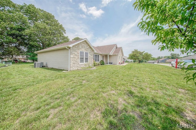11195 Lexington Ln, Rolla, MO 65401 - rear view of property with stone siding, central AC unit, and a lawn