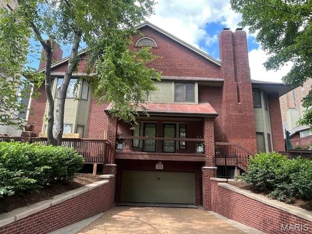 4465 W Pine Blvd Unit 15, Saint Louis, MO 63108 - view of front of house with a chimney, a garage, concrete driveway, and brick siding