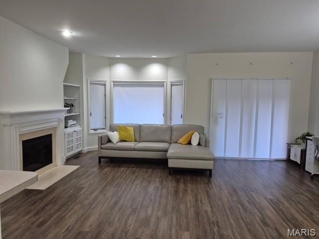 4465 W Pine Blvd Unit 15, Saint Louis, MO 63108 - living room featuring dark wood finished floors, built in features, a fireplace with flush hearth, and recessed lighting