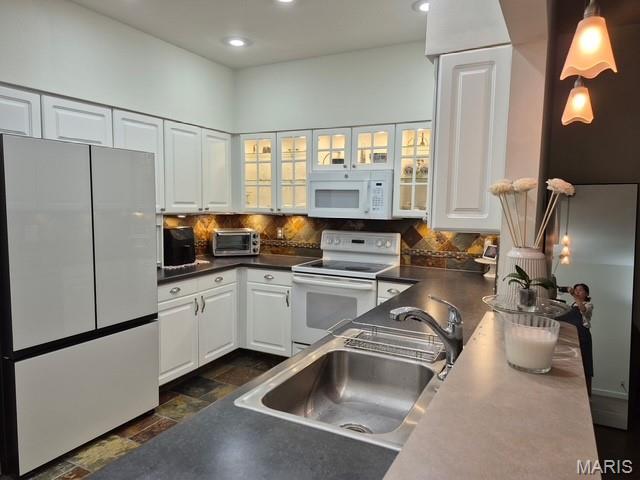 4465 W Pine Blvd Unit 15, Saint Louis, MO 63108 - kitchen featuring white appliances, dark countertops, white cabinets, tasteful backsplash, and recessed lighting