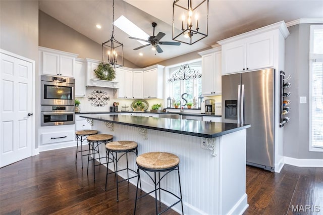 600 E Waters Edge Dr, Shiloh, IL 62221 - kitchen featuring stainless steel appliances, dark countertops, vaulted ceiling, a center island, and dark wood-style flooring