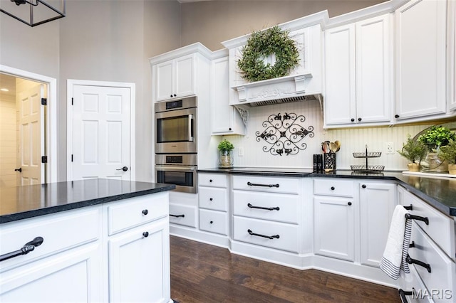 600 E Waters Edge Dr, Shiloh, IL 62221 - kitchen with stainless steel double oven, white cabinetry, dark wood-type flooring, black electric stovetop, and dark stone countertops