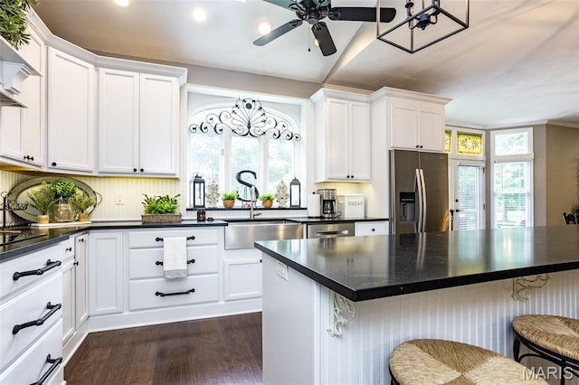 600 E Waters Edge Dr, Shiloh, IL 62221 - kitchen featuring appliances with stainless steel finishes, a sink, dark countertops, dark wood-style flooring, and a breakfast bar area