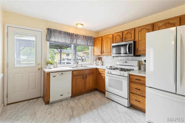 894 Napoli Dr, Ballwin, MO 63021 - kitchen with white appliances, plenty of natural light, light countertops, and brown cabinets