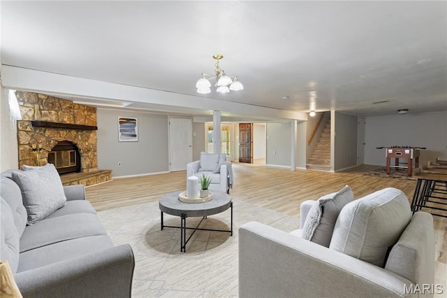 894 Napoli Dr, Ballwin, MO 63021 - living area with stairway, light wood-style flooring, a chandelier, and a fireplace
