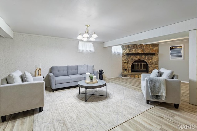894 Napoli Dr, Ballwin, MO 63021 - living room featuring a chandelier, a textured wall, wood finished floors, and a stone fireplace