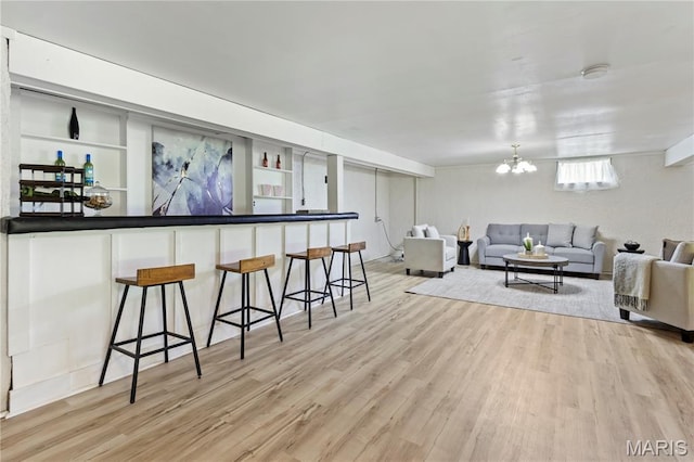 894 Napoli Dr, Ballwin, MO 63021 - living room with light wood finished floors, a chandelier, and bar