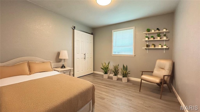 110 5th St, Park Hills, MO 63601 - bedroom with light wood-type flooring, baseboards, and a barn door
