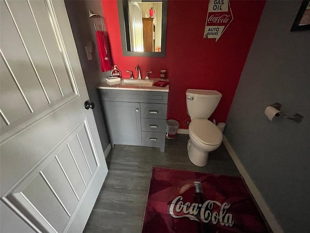 18428 Lake Circle Dr, Dexter, MO 63841 - half bathroom featuring vanity, toilet, baseboards, and wood finished floors