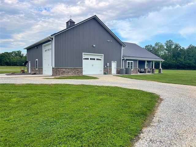 18428 Lake Circle Dr, Dexter, MO 63841 - view of front of house featuring a front yard, a chimney, central AC unit, stone siding, and board and batten siding
