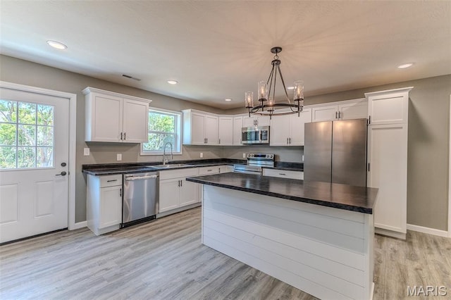 1223 Utah St, Lebanon, MO 65536 - kitchen with stainless steel appliances, a sink, a chandelier, white cabinetry, and dark countertops
