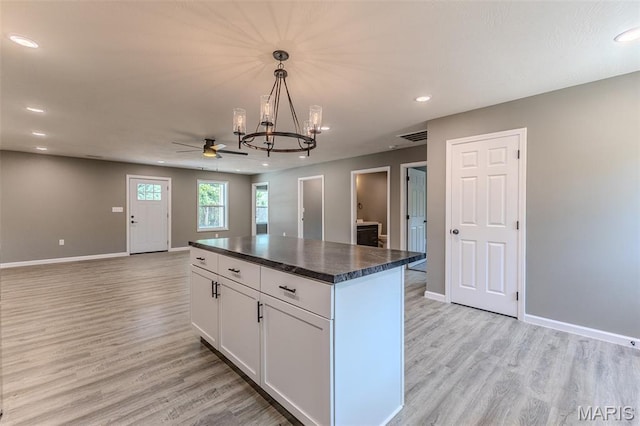 1223 Utah St, Lebanon, MO 65536 - kitchen featuring dark countertops, light wood-style floors, a chandelier, white cabinetry, and recessed lighting