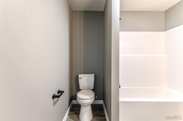 1223 Utah St, Lebanon, MO 65536 - bathroom featuring toilet, wood finished floors, baseboards, and  shower combination