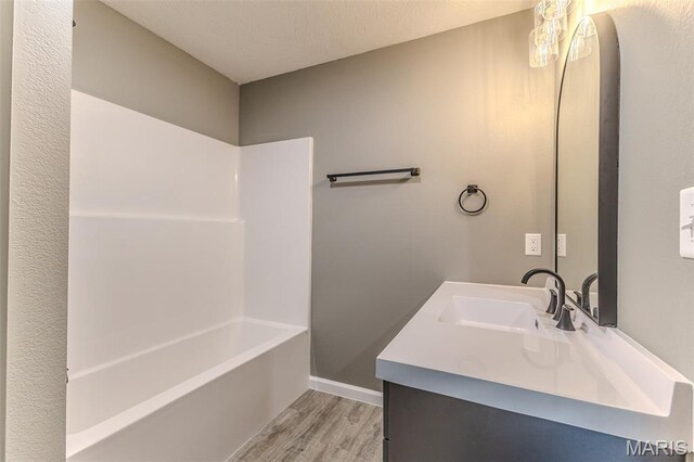 1223 Utah St, Lebanon, MO 65536 - full bath with wood finished floors, vanity, shower / bath combination, and baseboards