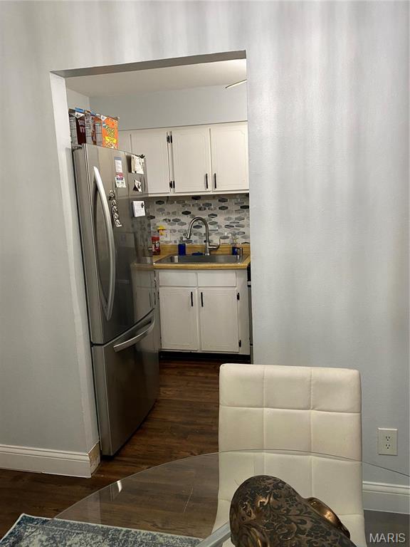 6966 Colonial Woods Dr Unit 62, Saint Louis, MO 63129 - kitchen with freestanding refrigerator, a sink, dark wood-type flooring, baseboards, and white cabinets