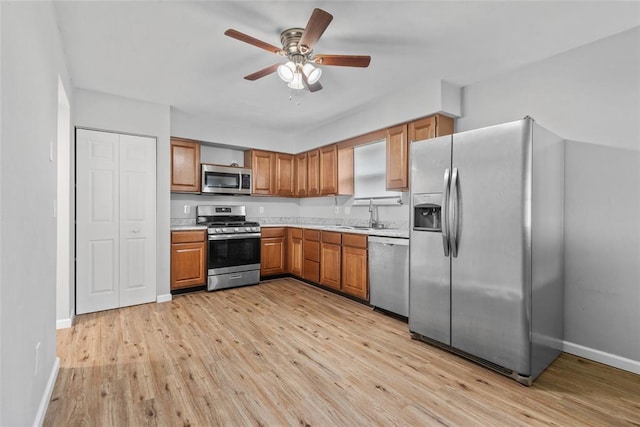 518 Bargraves Blvd Unit B, Troy, IL 62294 - kitchen featuring appliances with stainless steel finishes, light countertops, light wood-type flooring, ceiling fan, and brown cabinets