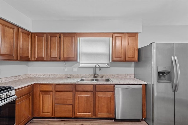 518 Bargraves Blvd Unit B, Troy, IL 62294 - kitchen with appliances with stainless steel finishes, a sink, brown cabinetry, and light wood-type flooring
