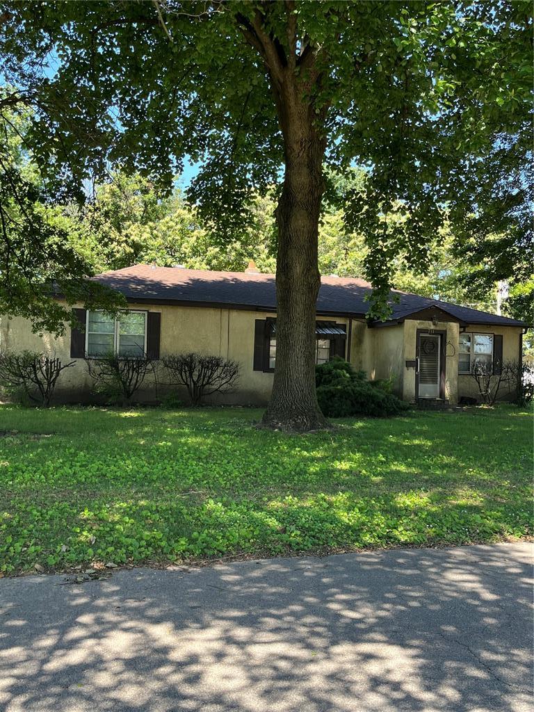 711 Lester St, Kennett, MO 63857 - view of front of house with a front yard and stucco siding