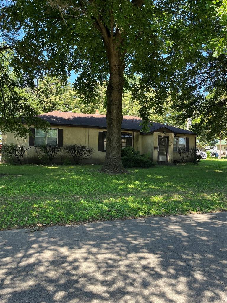 711 Lester St, Kennett, MO 63857 - view of front facade with stucco siding and a front lawn